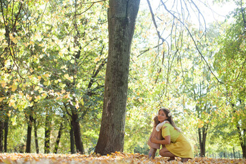 Beautiful young mother with her little daughter in park. Mother kissing her child outdoors. Family...