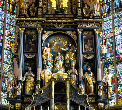 View of the interior of the Basilica St. Michael. A beautiful ornate altar, the walls are decorated with frescoes and images of saints. Mondsee, Upper Austria.