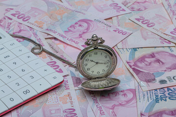 Turkish lira 200 TL counting and calculation. Hour and turkish liras bills, close up , shallow dof.