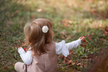 Little beautiful girl portrait in autumn street. Happy smart small girl in autumn park