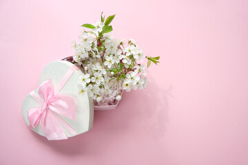 heart gift box with white cherry flowers on abstract pink background. spring season, festive composition. romantic gift for women. top view. copy space