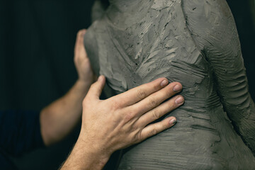 Man sculptor creates sculpt bust clay human woman sculpture. Statue craft creation workshop