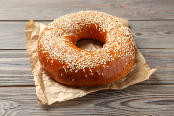 Delicious fresh bagel with sesame seeds on wooden table