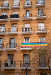 facade of a building with a gay pride flag on a balcony
