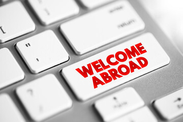 Welcome Abroad text button on keyboard, concept background