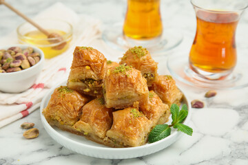 Delicious sweet baklava with mint on white marble table