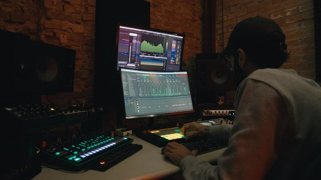 Boy dj producer is mixing a music with software on the computer