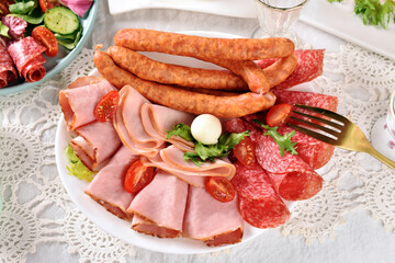Easter breakfast with a plate of ham and sausages and fresh salads