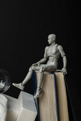 a man sits on books and dangles his legs