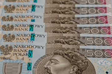 Zdjęcie przedstawiające plik banknotów 500 zł w różnych perpektyw