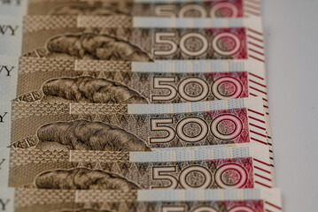 Zdjęcie przedstawiające plik banknotów 500 zł w różnych perpektyw