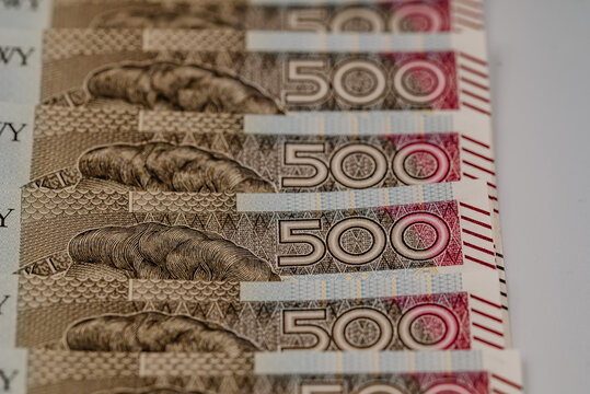 Zdjęcie przedstawiające plik banknotów 500 zł w różnych perpektyw