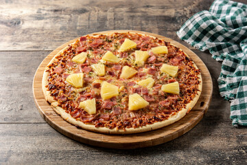 Hawaiian pizza with pineapple,ham and cheese on wooden table	