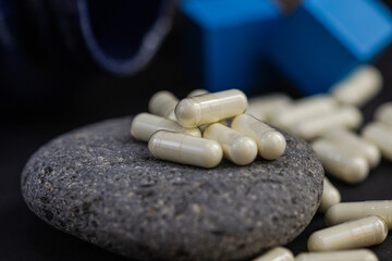 white capsules on stone with black background