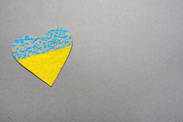 Save Ukraine sign support concept heart shape love UA. National symbol ukraine painted child drawing heart isolated on gray background. No war kids making symbol heart Ukraine flag painted yellow blue