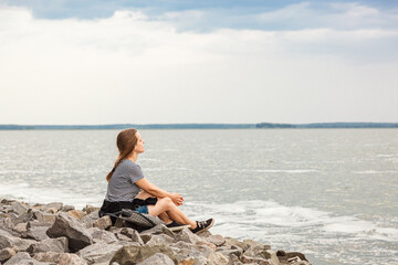 Beautiful girl on the sea with blue sky and clouds