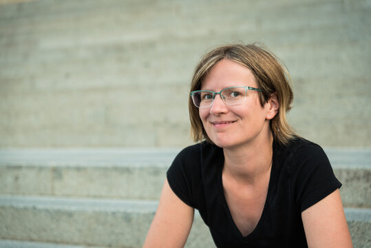 Portrait Of A Thirty Year Old White Woman With A Concrete Stairs Background