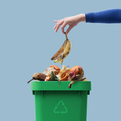 Woman putting organic waste in the recycling bin - 493221621