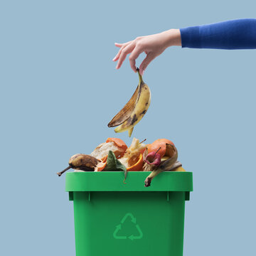 Woman putting organic waste in the recycling bin