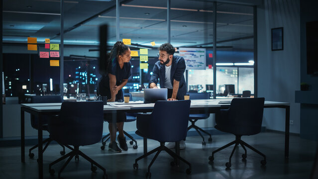 Businesspeople in Modern Office: Business Meeting of Two Managers. Female CEO and Marketing Director Talk, Brainstorm Corporate Strategy, Implementing Marketing and Financial Plans. Evening Time.