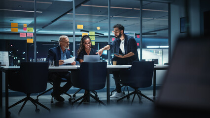 Office Conference Room Meeting: Diverse Team of Top Managers Talk, Brainstorm, Use Laptop Computer. Business Partners Discuss Financial Reports, Plan Investment Strategy and Managerial Operations.