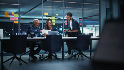 Fototapeta premium Office Conference Room Meeting: Diverse Team of Top Managers Talk, Brainstorm, Use Laptop Computer. Business Partners Discuss Financial Reports, Plan Investment Strategy and Managerial Operations.