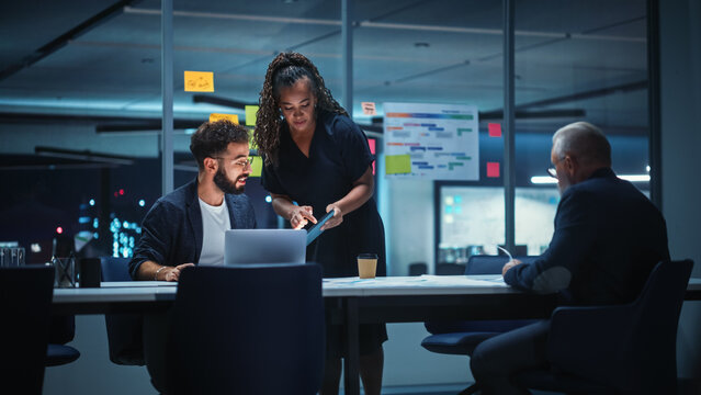 Office Conference Room Meeting: Diverse Team of Top Managers Talk, Brainstorm, Use Digital Tablet. Business Partners Discuss Financial Reports, Plan Investment Strategy. Team of Three