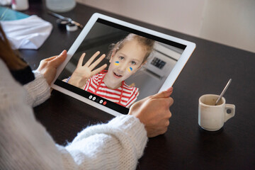 videochiamata con bambina che riposta segnati sulla faccia  i colori dell' Ucraina