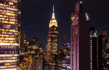 Obraz na płótnie Canvas A shot of the Empire State Building Manhattan New York citiscape skyline at night. The shot was taken on 42nd St looking into the skyscrapers lit up with their internal lights