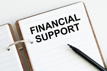 Financial Support text written on a notebook with pencils