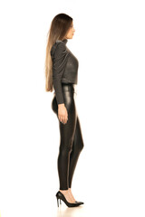 Fototapeta premium An attractive young woman posing in gray blouse and latex trousers. Fashion look on a white background.