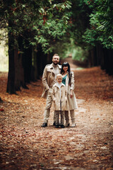 A happy family is walking in the park. Mom, dad and son are chatting and walking. A stylish family. parents in love.