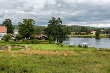 View over the Swedish countryside around Segersta with Agricultural fields, trees, grass and a pond
