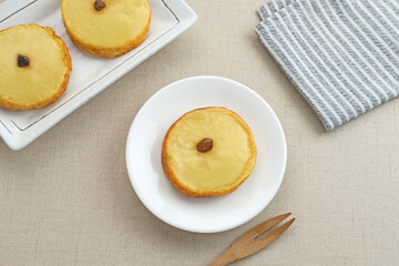 Kue Lumpur or Mud Cake, Indonesian traditional snack made from potatoes, flour, eggs and coconut milk topped with raisins. Selected focus.
