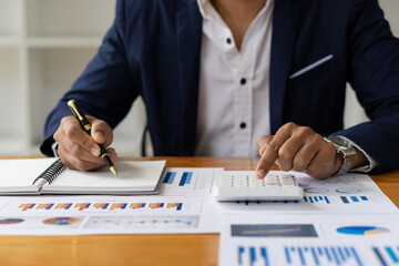 Fototapeta premium An accountant, businessman, or financial professional analyzes business report graphs and computational charts at the company's office. Banking business economy concept. and stock market research