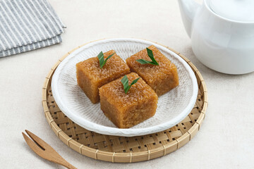 Wajik, traditional Indonesian snack made from steamed sticky rice, palm sugar, coconut milk, and pandan leaves. Selected focus.
