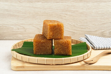 Wajik, traditional Indonesian snack made from steamed sticky rice, palm sugar, coconut milk, and pandan leaves. Selected focus.
