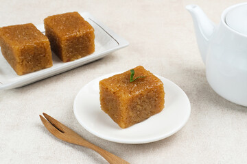 Wajik, traditional Indonesian snack made from steamed sticky rice, palm sugar, coconut milk, and pandan leaves. Selected focus.
