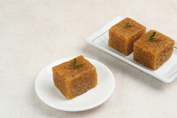Wajik, traditional Indonesian snack made from steamed sticky rice, palm sugar, coconut milk, and pandan leaves. Selected focus.
