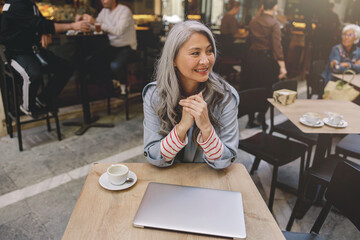 Positive woman during coffee time in cafe