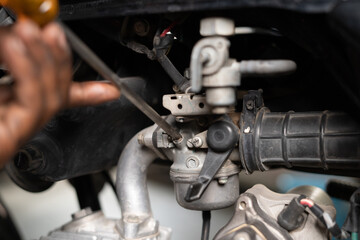 Fototapeta na wymiar Close up shot of mechanic busy fixing motorbike air filter at garage - concept of repair and maintenance service.