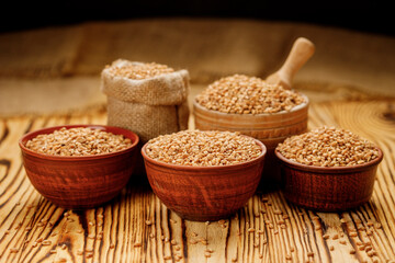 Pearl barley groats in bowls and bags on a wooden background. High quality photo