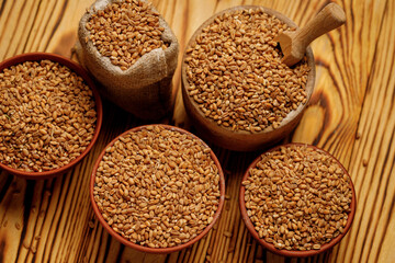 Pearl barley groats in bowls and bags on a wooden background. High quality photo