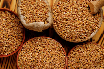 Pearl barley groats in bowls and bags on a wooden background. High quality photo