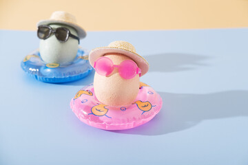 A fun Easter travel arrangement with two eggs in inflatable swimming circles and sunglasses