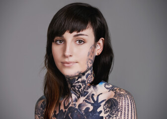 Artistic attire. A cropped studio portrait of a tattooed young woman.