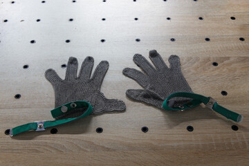 Metal protective gloves on cutting table of Tape Cutting Machine.