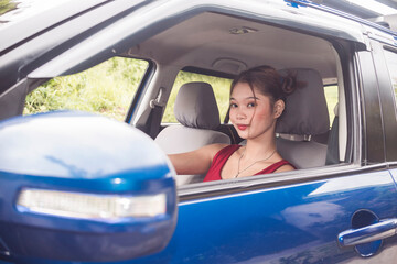 A young beautiful woman driving. Showing a confident emotion about her driving skills. Right...