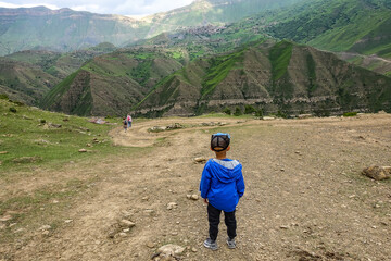 A boy on the background views of the mountains of Dagestan near the village of Gamsutl. Russia June 2021