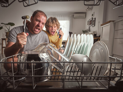 Angry father with son near broken dishwasher